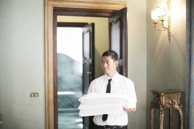 Employé d'hôtel portant du linge propre dans un couloir